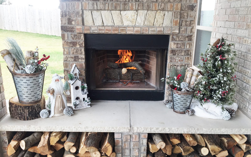 Rustic Christmas Decorations on an outdoor fireplace. Outdoor Christmas Patio and porch decoration ideas.